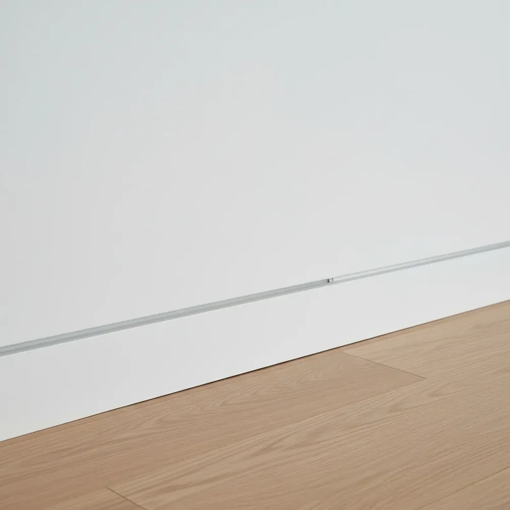 Flush modern baseboard aligned with the finished wall surface