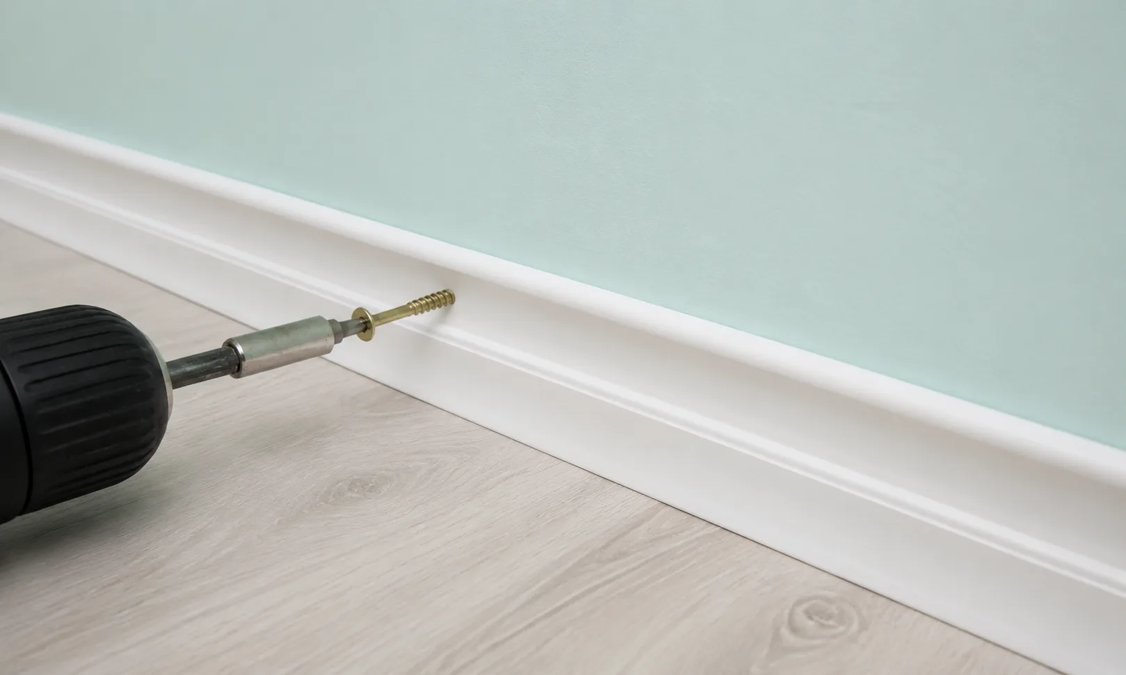 Removing a visible screw from a skirting board with a drill