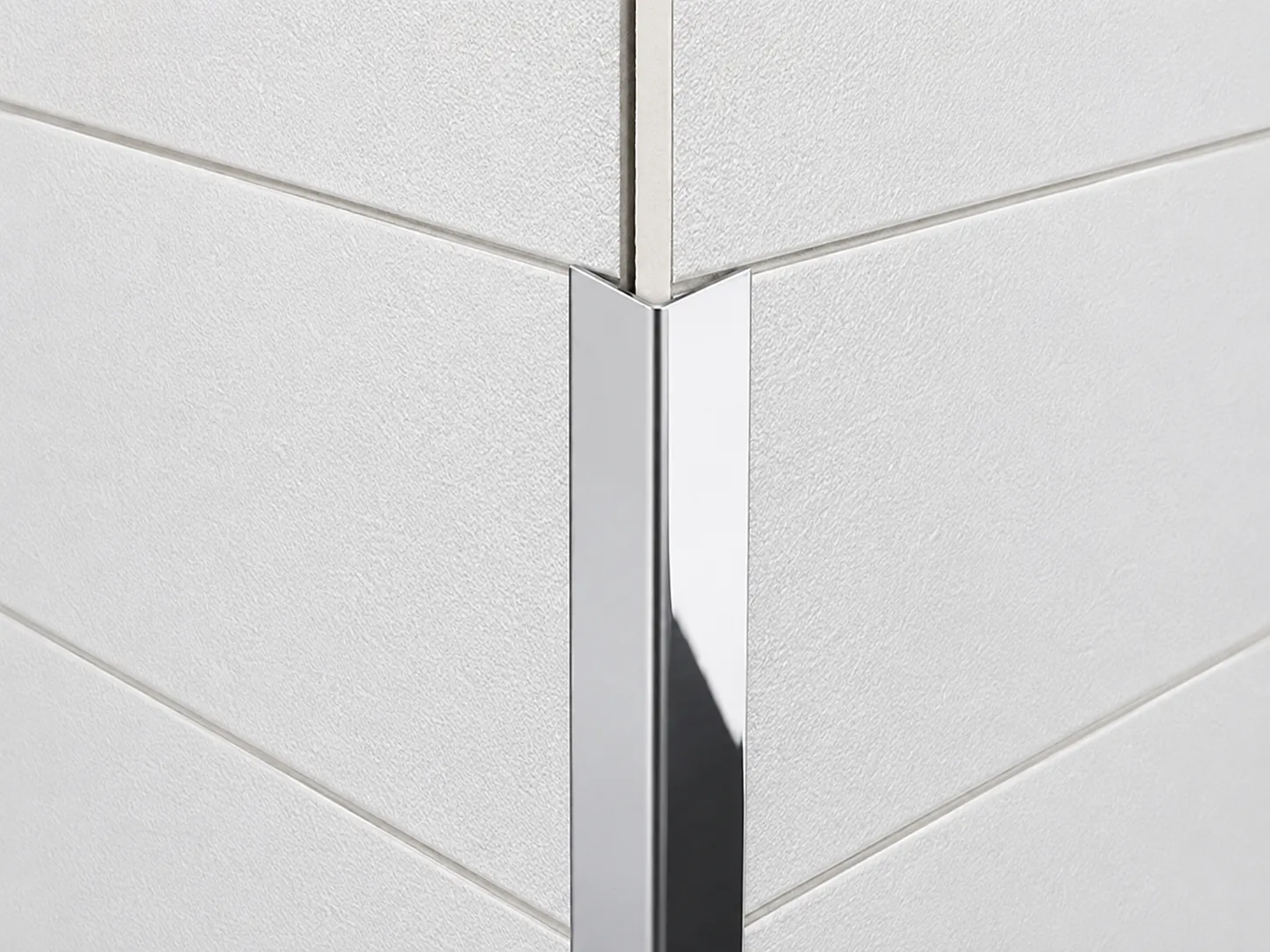 Polished stainless steel corner trim protecting an external wall corner