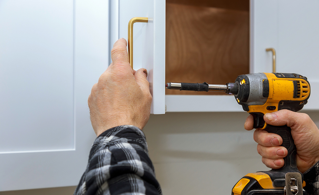 Kitchen cabinet handles tested with tape before drilling cabinet doors