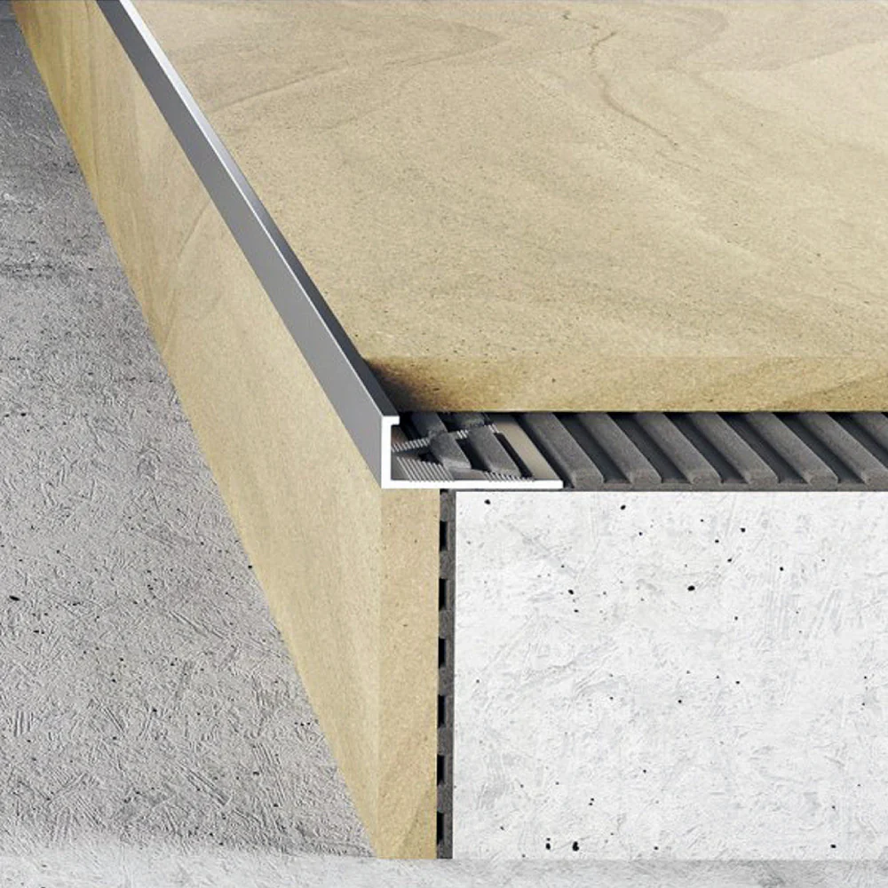 Cross-section of aluminum tile edge trim installed under a ceramic tile