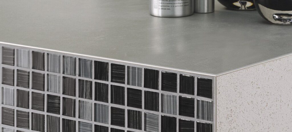 Tile edge trim finishing a countertop corner with mosaic tile