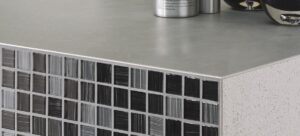 Tile edge trim finishing a countertop corner with mosaic tile