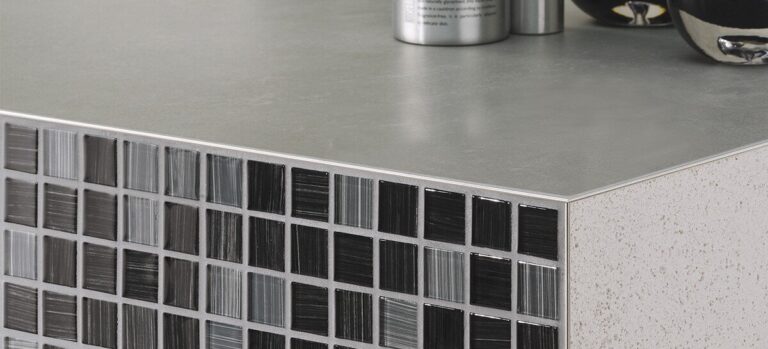 Tile edge trim finishing a countertop corner with mosaic tile