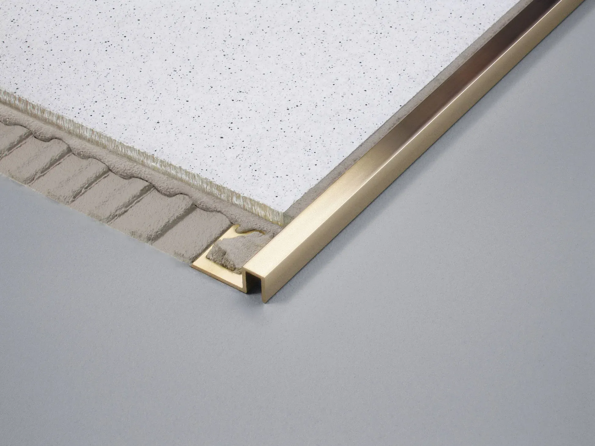Applying tile adhesive evenly before installing metal tile edge trim