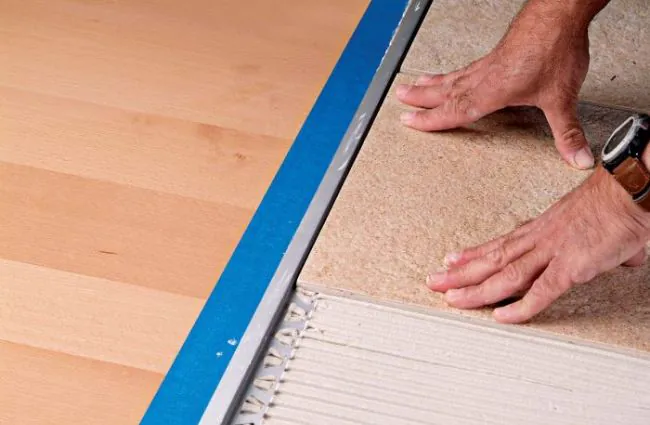 Installing a tile firmly against metal tile edge trim with a consistent joint