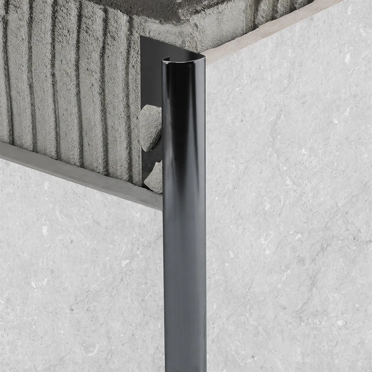 Round metal tile edge trim profile with a curved visible face for bathroom corners