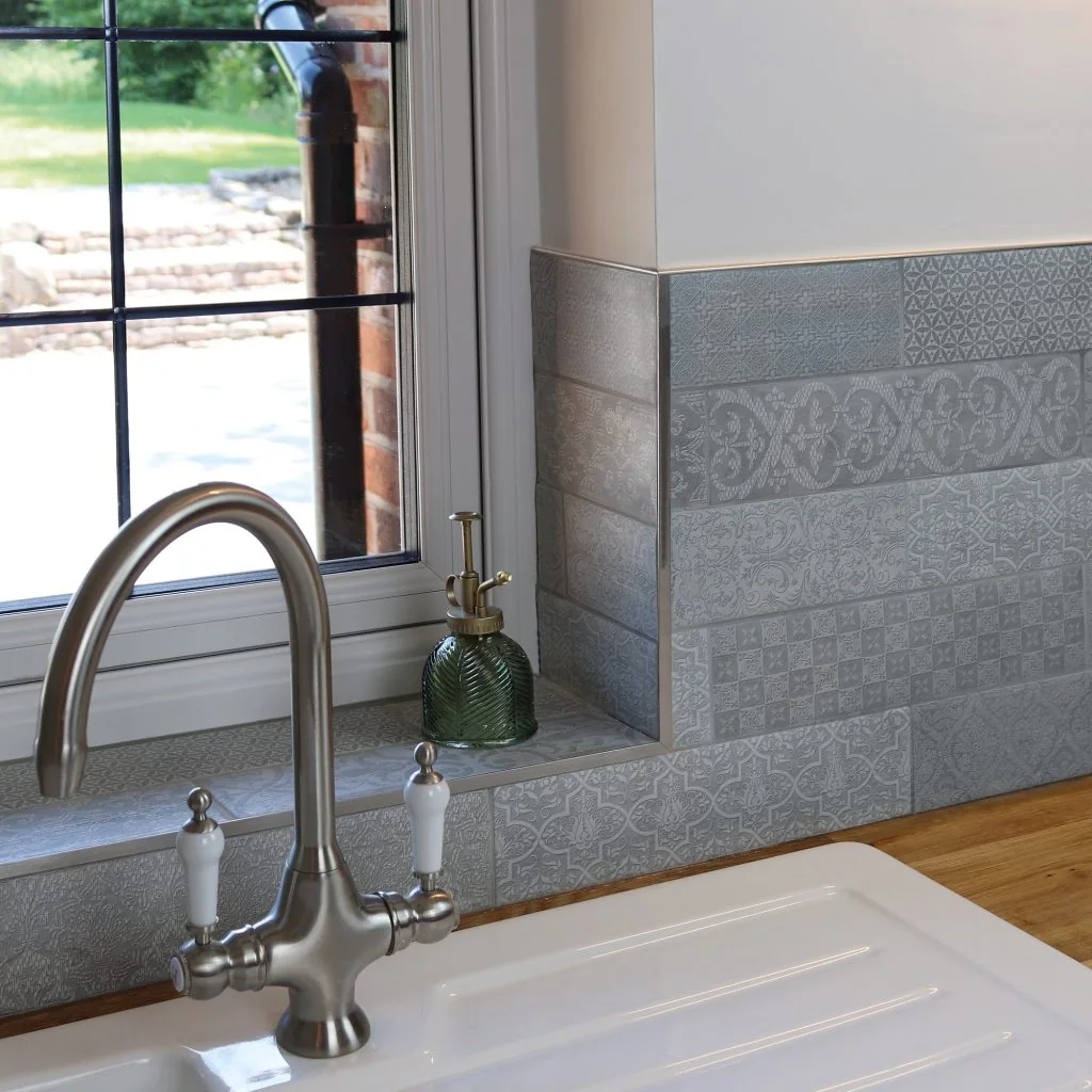 Metal profile around a tiled window reveal