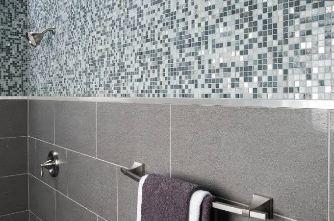 Decorative metal profile forming a border between tiles