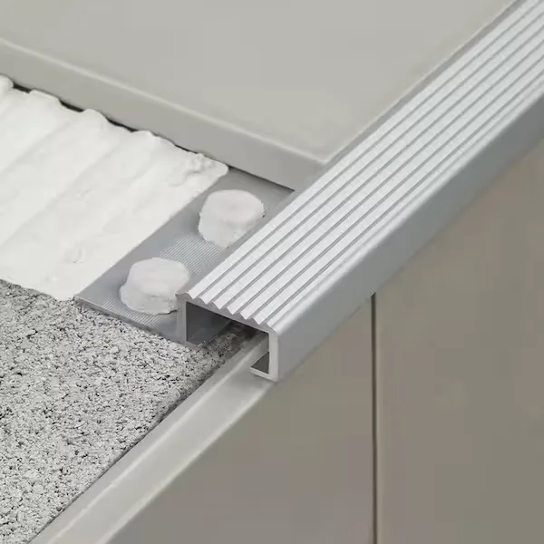 Tile-in stair profile with an anchoring flange beneath the tile