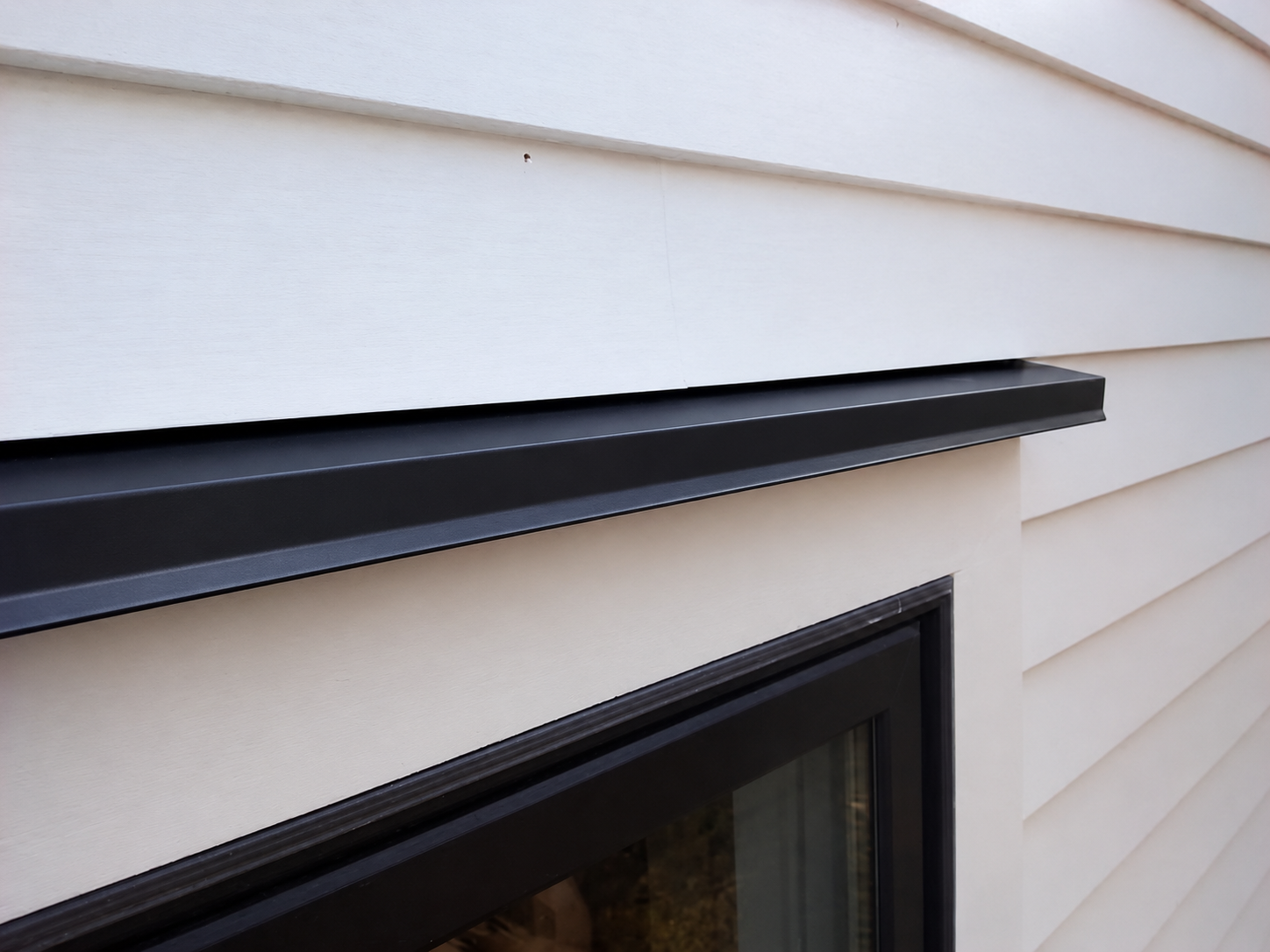 Window head and horizontal drip edge trim installed above an opening
